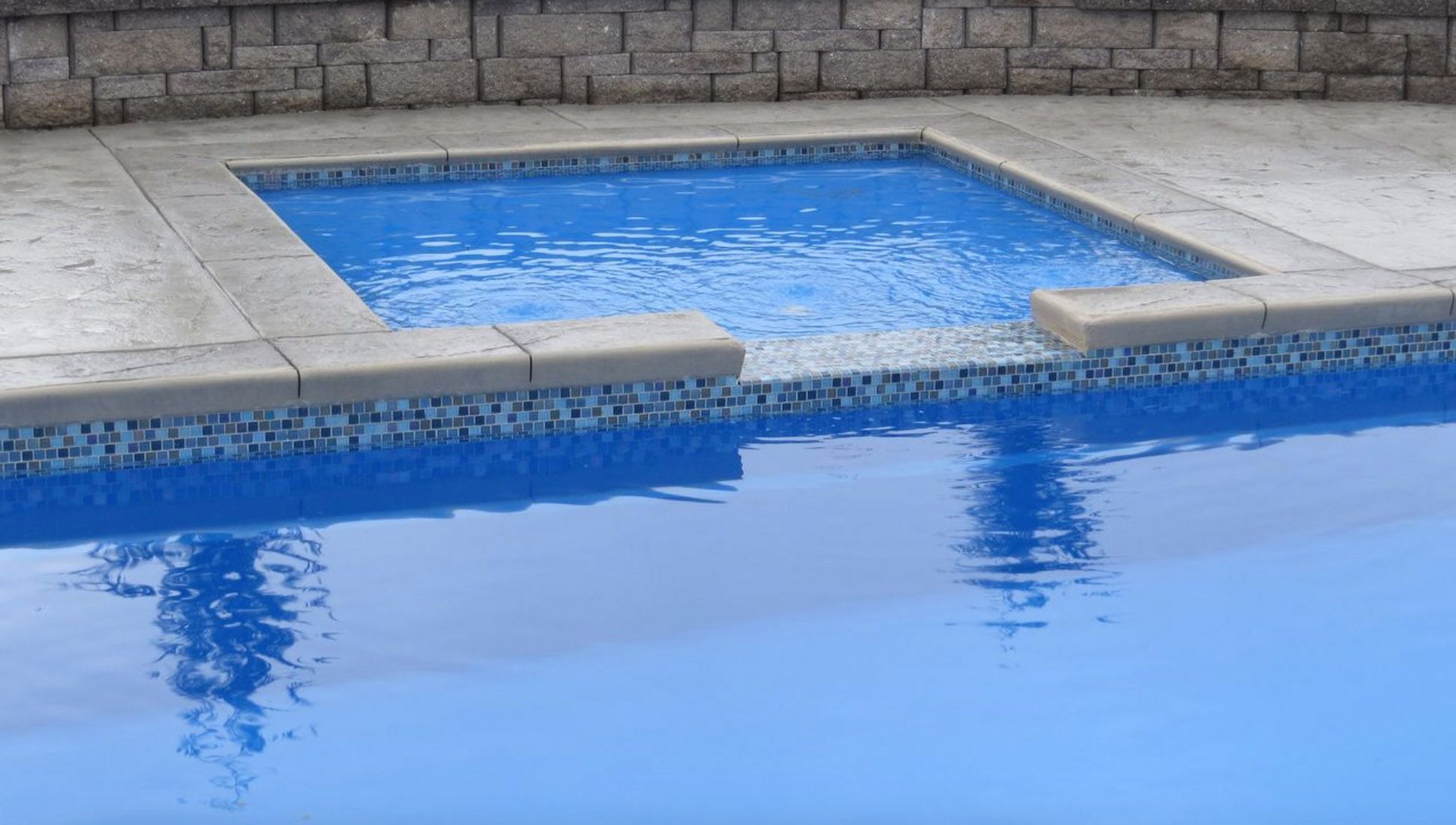 swimming pool with waterline tile and tanning ledge