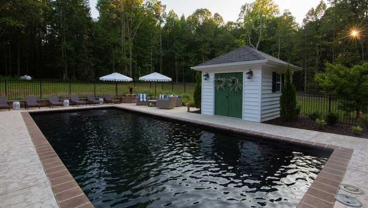 pool house next to black fiberglass swimming pool