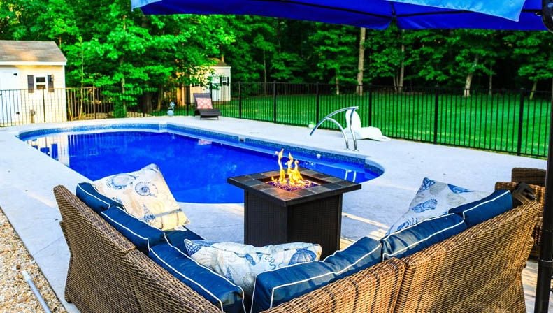 pool with patio furniture and fire pit